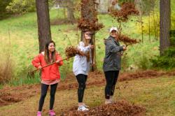 Students playing with leaves while raking