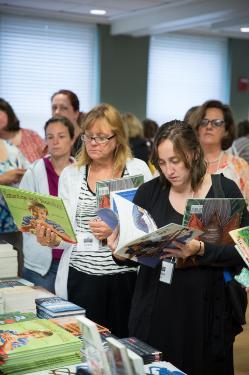Participants looking at books during 2015 Summer Literacy Institute
