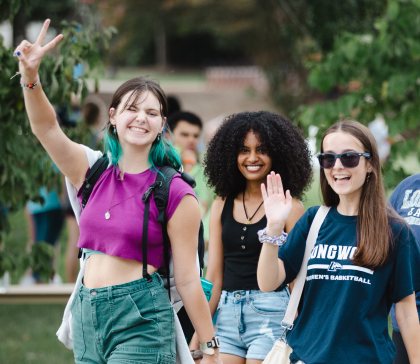 Students walk on campus and smile for the camera.