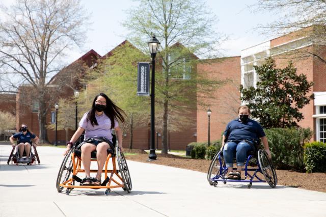 Two students trial sports wheelchairs.