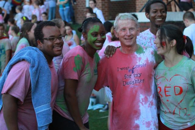 President Patrick Finnegan poses with students after participating in Color Wars. 