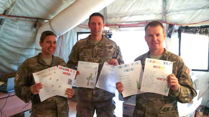Soldiers holding cards from the the Letters to Soldiers Club