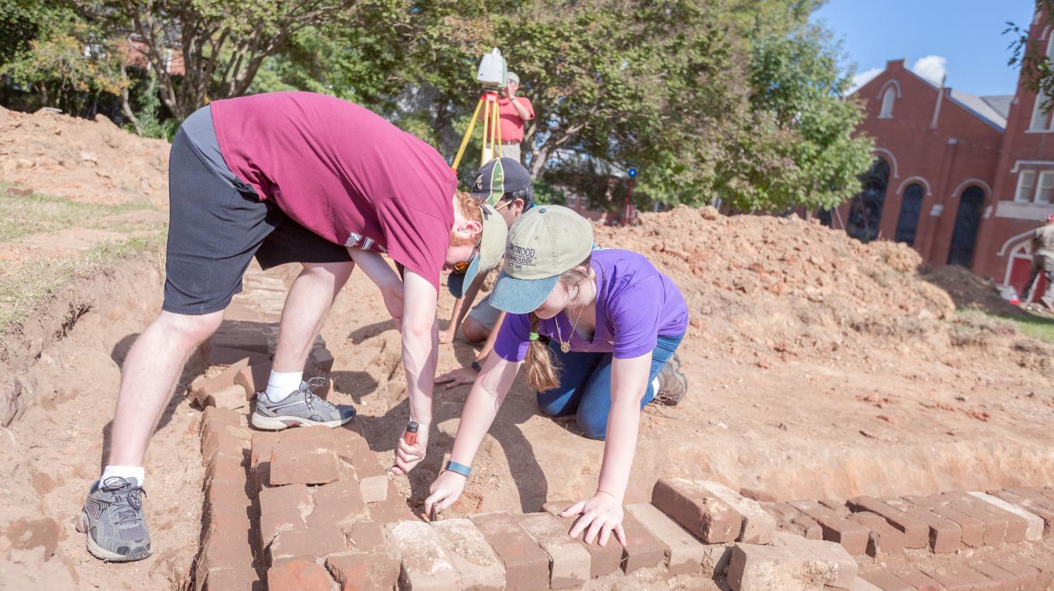In a class-related archaeology survey, Ashton Chandler ’18, an anthropology major from Leesburg, and Jessica Keaton ’17, an anthropology major from Forest, uncover the foundation of the Richardson House in Bicentennial Park, which stood where the new admissions building will be built.