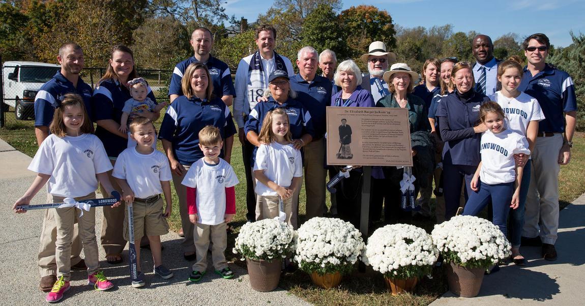 Dr. Jackson's family and friends stand near the special plaque that will reside on the concourse of Burger Jackson Field at the Longwood Athletics Complex.
