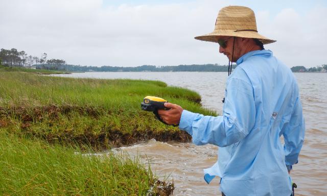 Craig Rose ’00 of the Longwood Institute of Archaeology maps a Mathews County shoreline with a high-accuracy GPS.
