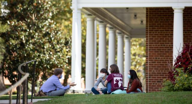 Dr. Sean Ruday holds office hours on the lawn outside Grainger
