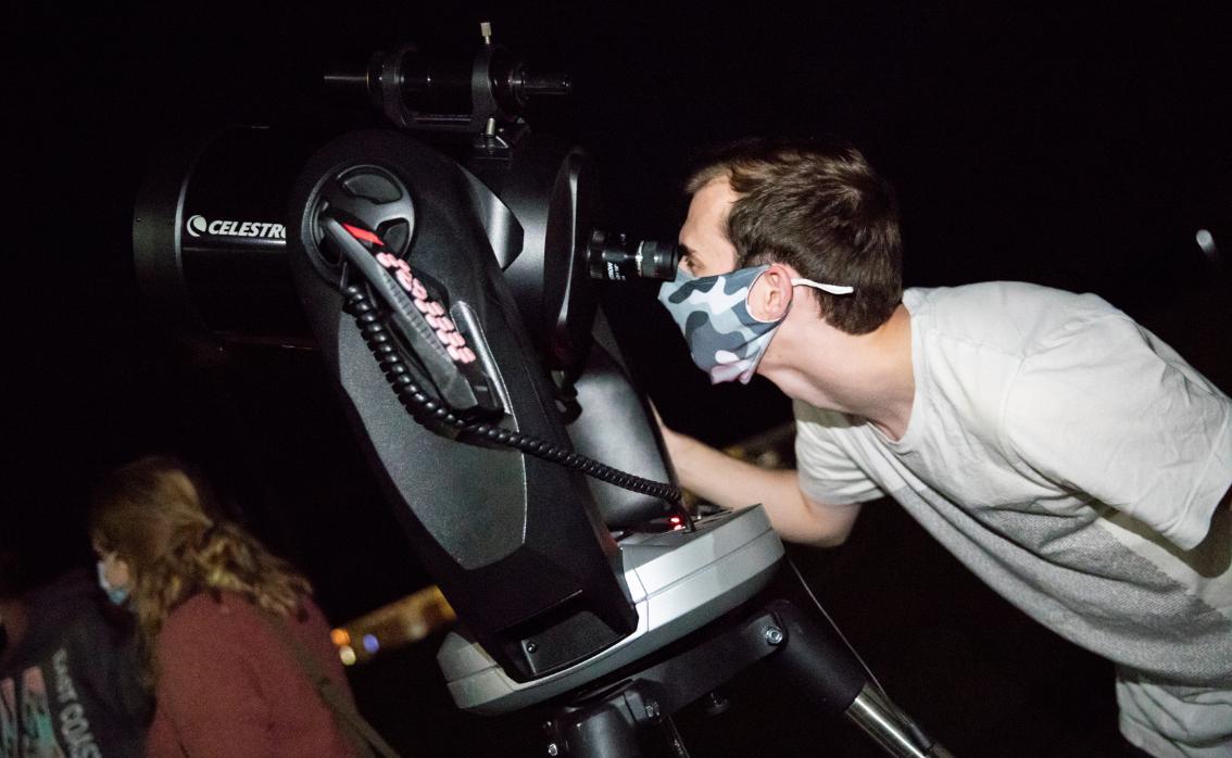Austin Hedges ’21, president of the Society of Physics Students, sets up the telescope for the evening’s stargazing. The telescope has a GPS system that is programmed with the locations of thousands of celestial objects.