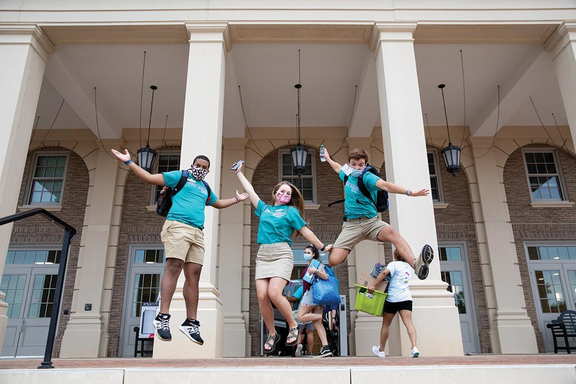 Student Ambassadors jumping outside one of the high rise residence halls