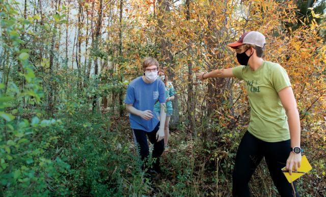 Putting their orienteering skills to the test in the wooded area behind Longwood House are Abbey Mays ’22 (right), a therapeutic recreation major; Josh Bain ’23 (left), a psychology major; and Crystal Rosenbaum ’21, a nursing major.