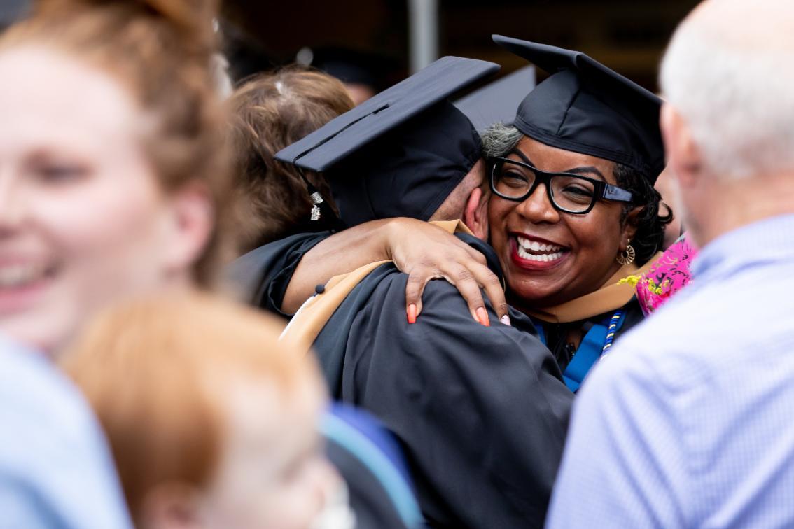 Graduates hugging at the graduate school ceremony