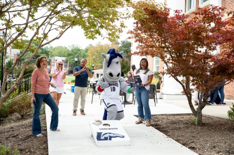 Longwood alumni and board members cheer on Elwood during a Career Success porch party.