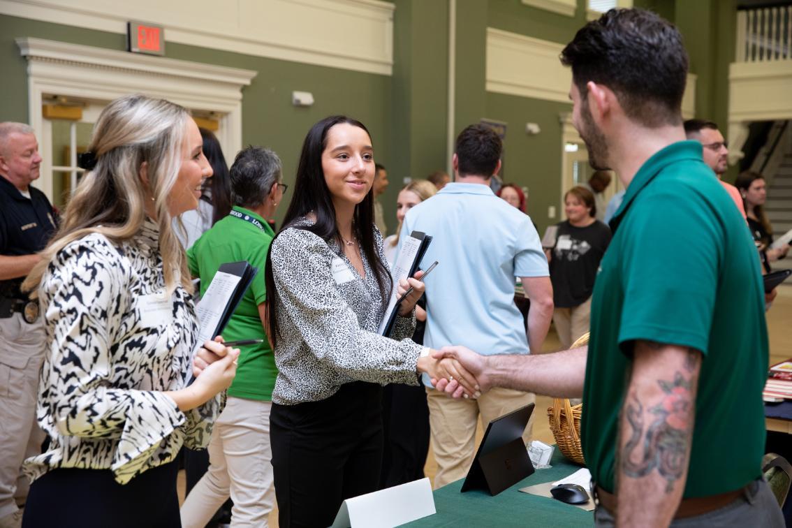 Student shaking hands with an employer during a career fair