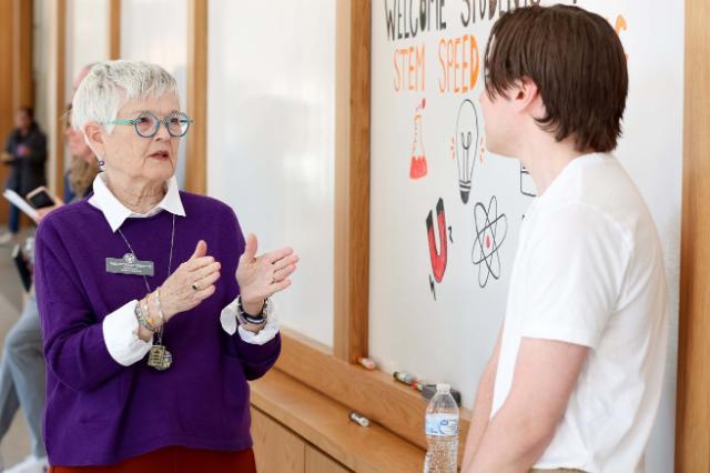 Older alum chatting with a student at a career networking event.