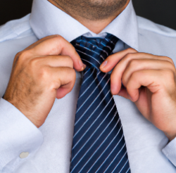 a man tying a neck tie