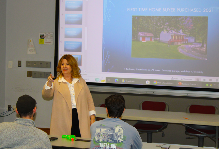 Patrice Carroll standing at the front of the classroom. -