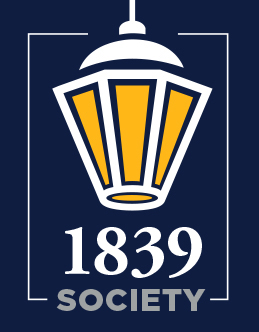 1839 Society Graphic -Illustrated logo featuring a gold and white lantern above the words “1839 Society.” The design is framed by thin white lines on a navy blue background. The lantern symbolizes Longwood University’s tradition and guiding light. “Society” is written in bold gray capital letters beneath “1839.”
