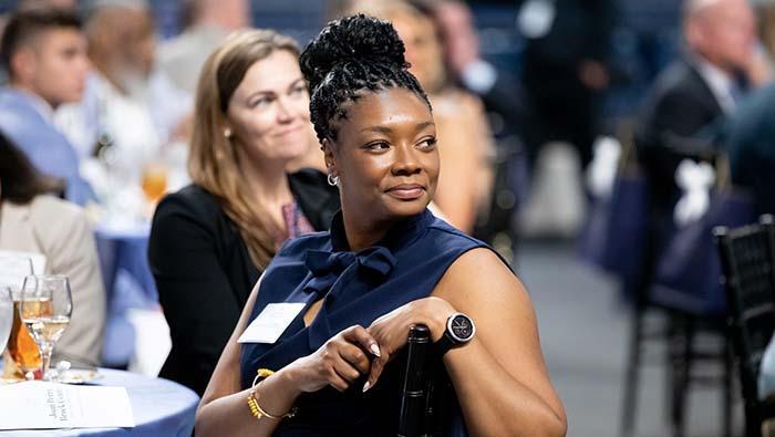 Two people at an event smiling at something happening