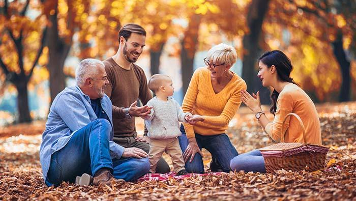 Photo of a family playing in leaves in fall