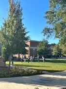 Students participating in recreation on a sunny day with blue skies.