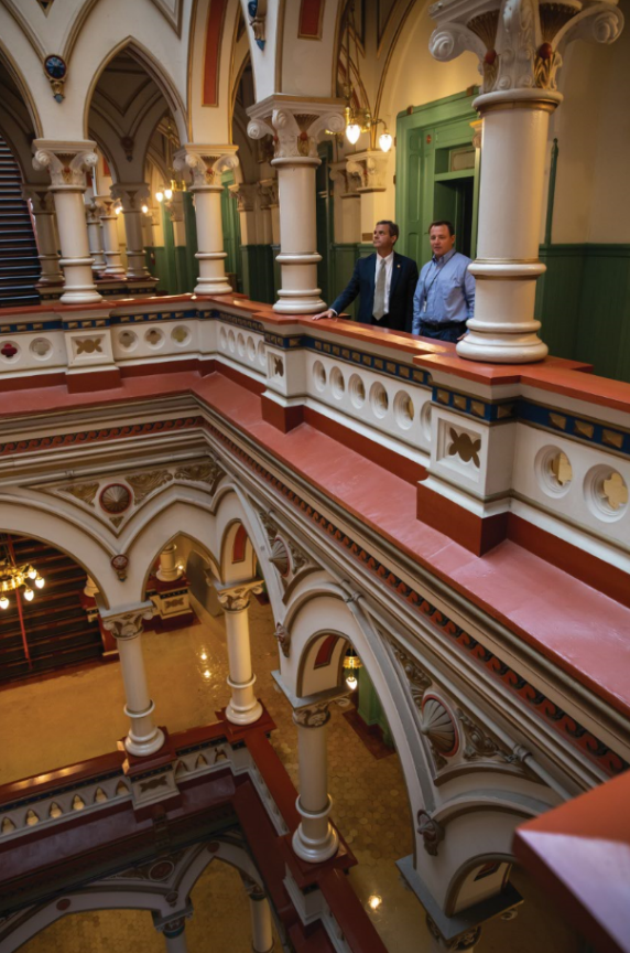 Damico (left) and Tom George, director of the Office of Planning, Design and Construction for DGS, discuss details of the renovation of Richmond’s Old City Hall, a Victorian gothic building completed in 1894. 