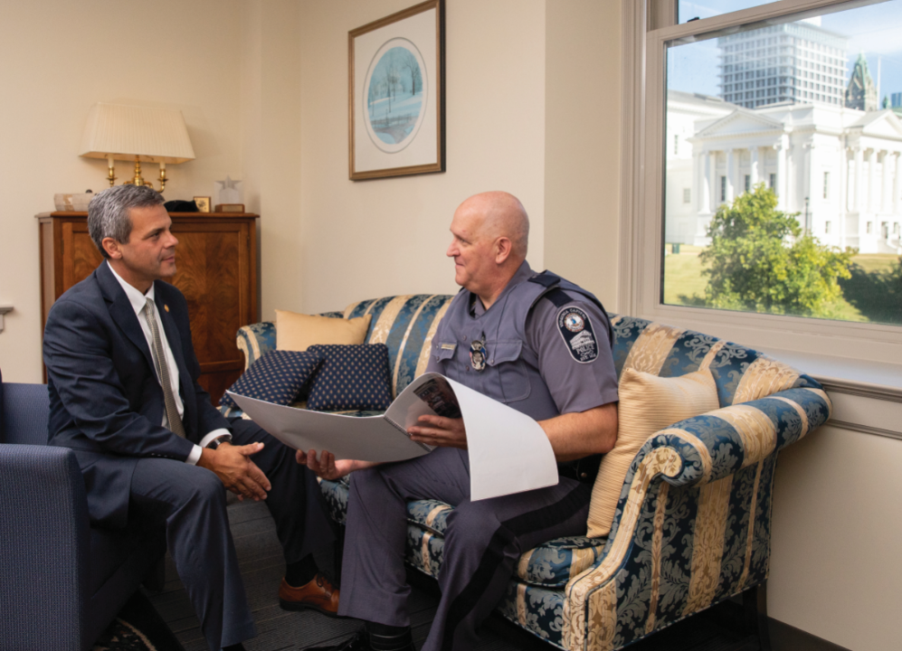 Policeman  DGS and the Capitol Police often work together on initiatives and activities that take place on state property, including the state Capitol, framed here in Damico’s office window. Damico (left) and Maj. Mark Sykes discuss an upcoming event.
