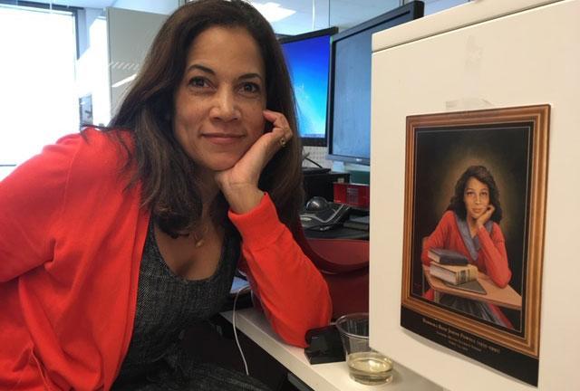 Sydney Trent is pictured with a photo of her godmother, Barbara Johns, at her desk in the Washington Post newsroom.