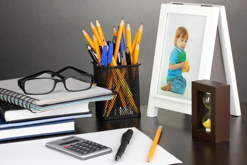 A desk, including a photo of a child. Image courtesy of Shutterstock