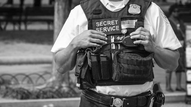 Washington DC, USA - July 2, 2016: A U.S. Secret Service officer, wearing a vest with various equipment attached, stands on Pennsylvania Avenue outside the White House.