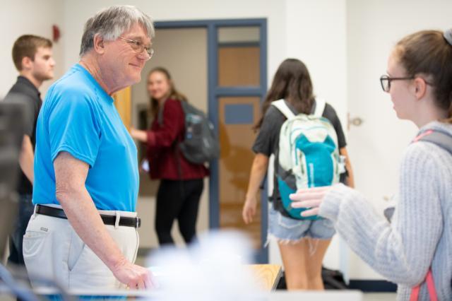 Craig Challender speaks to a student after his last class before retirement