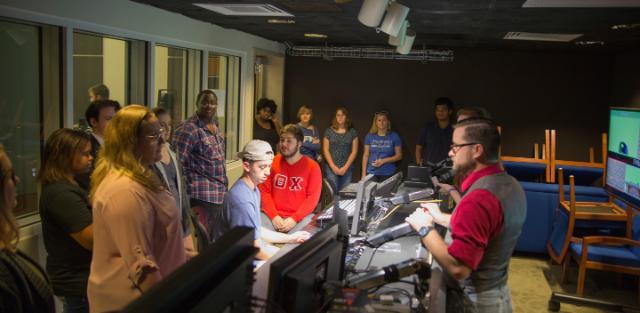 Clint Wright (right) shows students in his first-year coaching group around the production and editing room in Longwood’s communication studies broadcast studio.