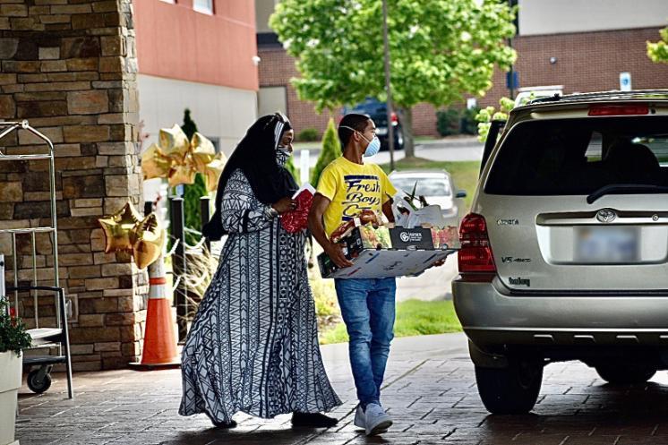 Jalila Ahmad, president of A&J Consulting LLC, and FreshBoyz member Elijah Taylor deliver one of more than 60 boxes of food distributed in May as part of the Box of Blessings community initiative.