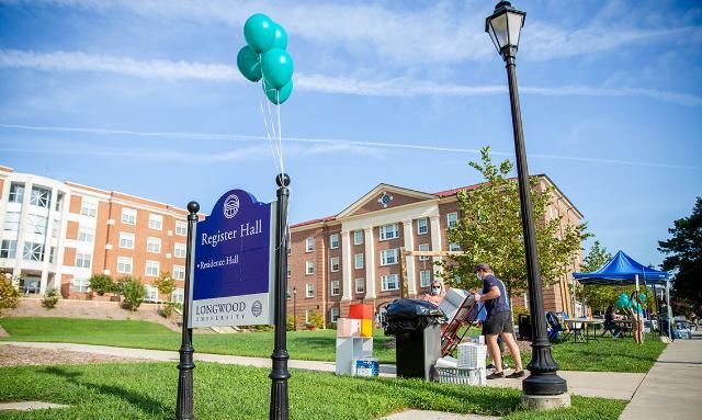 Family outside Register Hall with cart and boxes ready to move student in