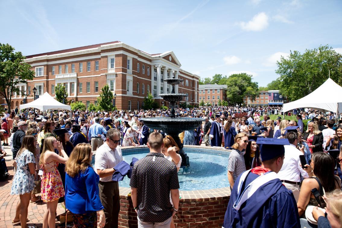 Graduates and their families congregate around the fountain after the Commencement ceremony