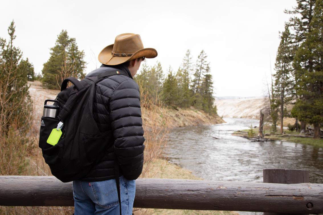 Yellowstone experience student pauses for a moment of reflection atop wooden bridge