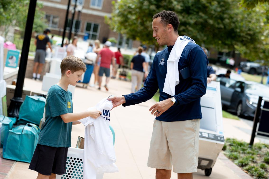 Men’s basketball head coach Ronnie Thomas handed out t-shirts to Lancer newcomers and their families.