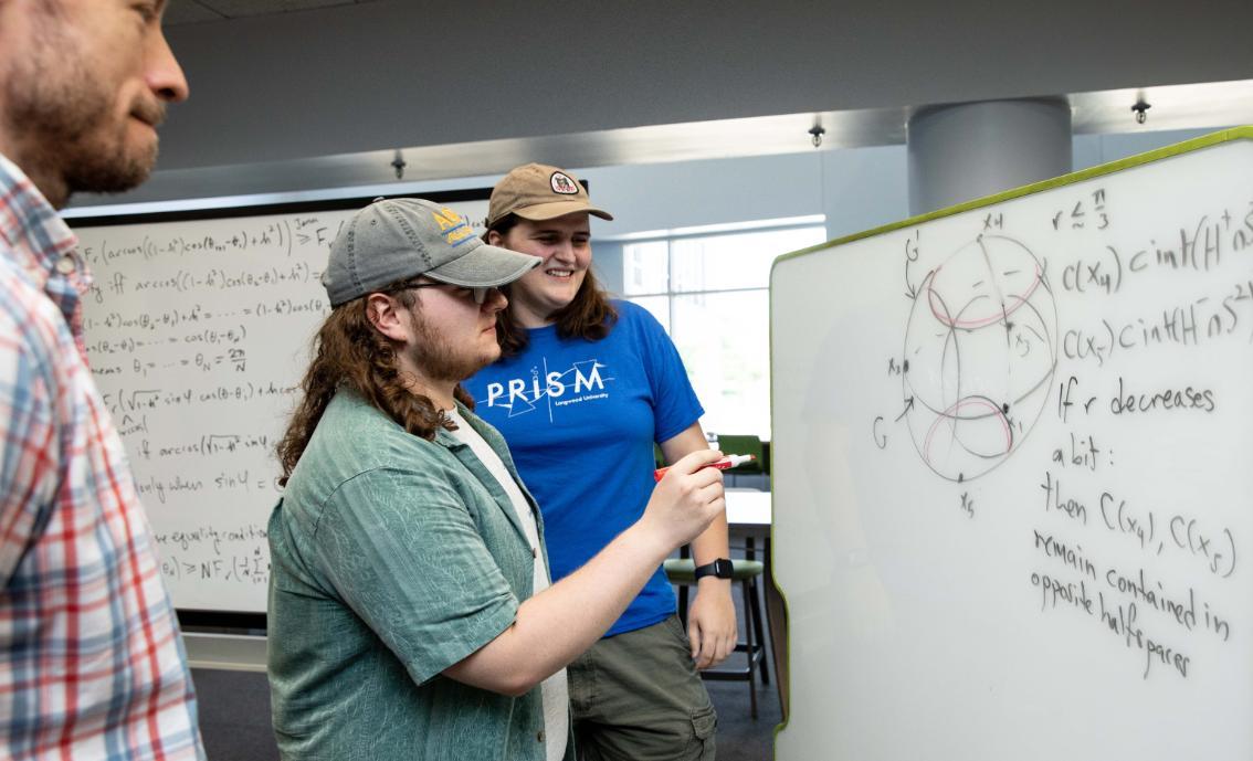 Ryan Childress ’26 and Emma Heisig ’28 working on their math research with  Dr. Steven Hoehner