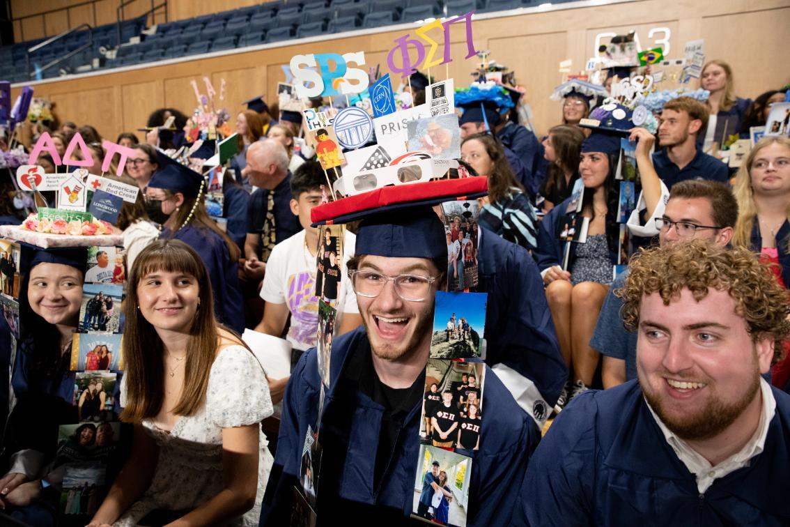 Student grins while wearing their decorated cap.