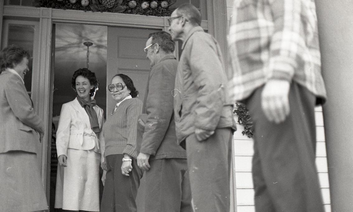 Dr. Greenwood (second from left) welcomes guests to Longwood House for a holiday celebration.